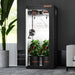 Spider Farmer® 2.3’x2.3’x5.2′ Grow Tent Garden pod with plants inside, placed indoors next to a plant and a chair.