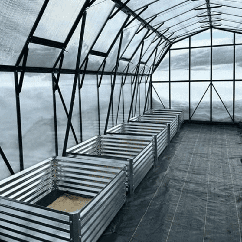 Grandio Summit Greenhouse side view with planters in snowy conditions 