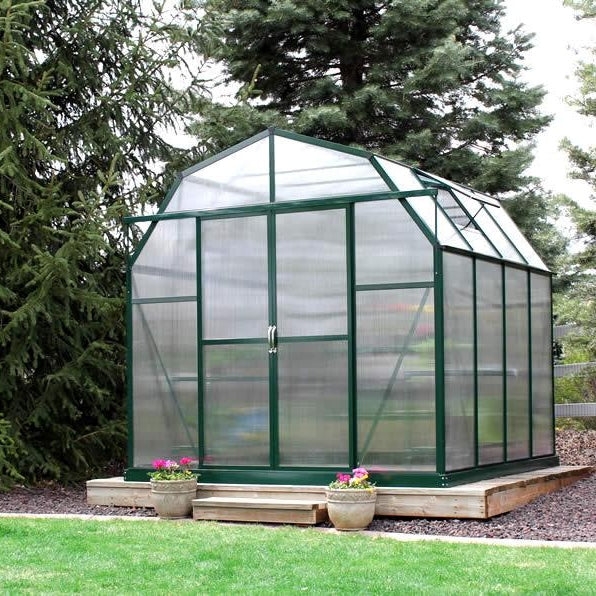 Grandio Elite Greenhouse front facing door closer next to pine trees 