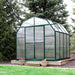 Grandio Elite Greenhouse front facing door closer next to pine trees 