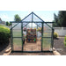 Grandio Ascent Greenhouse in backyard front facing with door open with flowers inside 